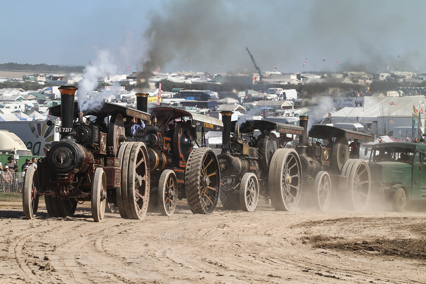 IMG 3727 
 The Great Dorset Steam Fair 2013. 4 Traction engines pulling a load around the 'Playpen'. 
 Keywords: Great Dorset Steam Fair 2013 GDSF Traction Engine Heritage Photography Photo Photos British Tarrant Hinton 4 Four Traction Engines Pulling Load Around Playpen Heavy Haulage Arena Wheel Wheels Canopy Boiler Smoke Dust