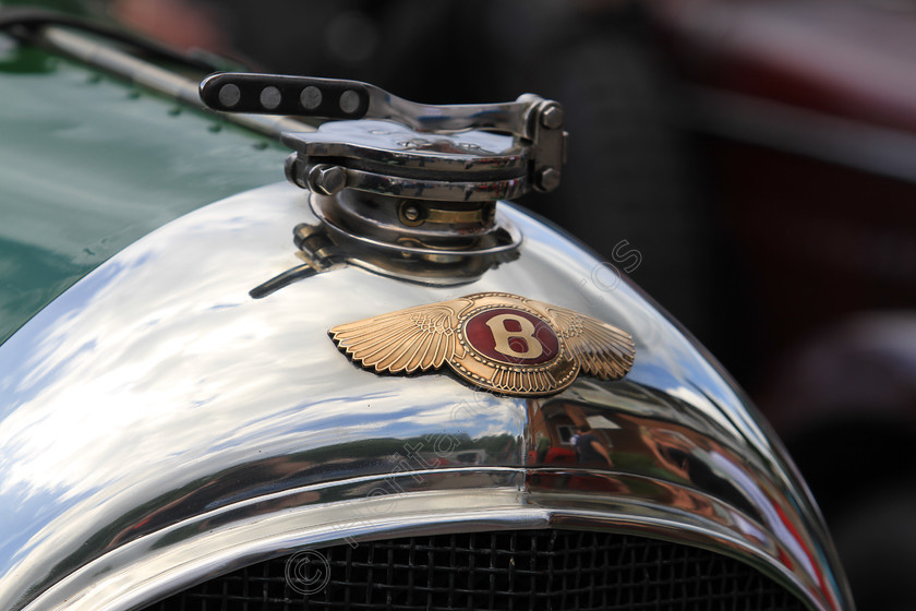 IMG 4889 
 Bentley vintage car insignia and radiator cap detail. 
 Keywords: Bentley Vintage Car Insignia Logo Badge Radiator Cap Detail Green Silver Classic British Engine Transport Reflection